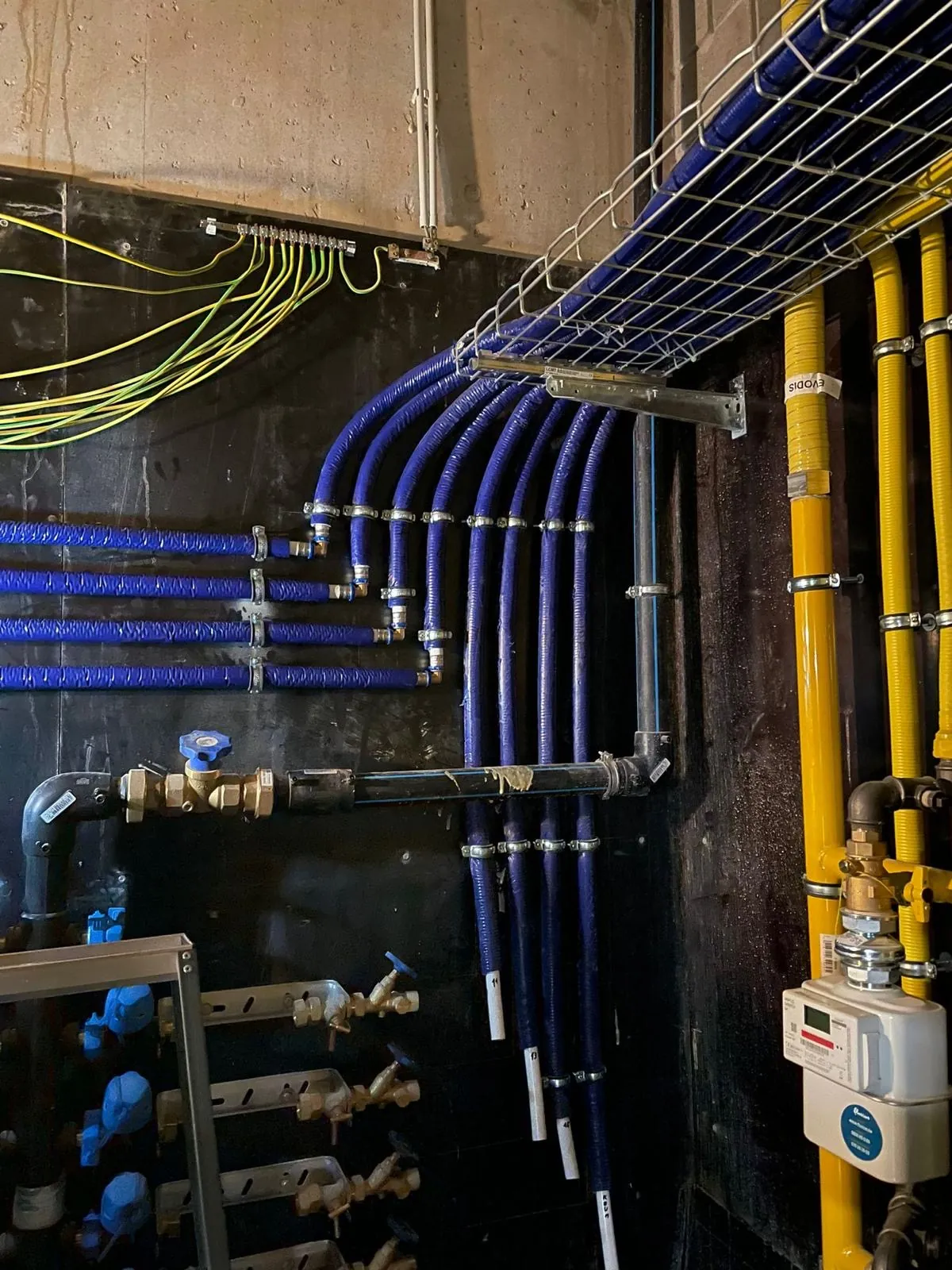 Geïsoleerde waterleidingen op kabelgoot naar de individuele aansluitingen van een gebouw, werk van HS Concept in Aalst