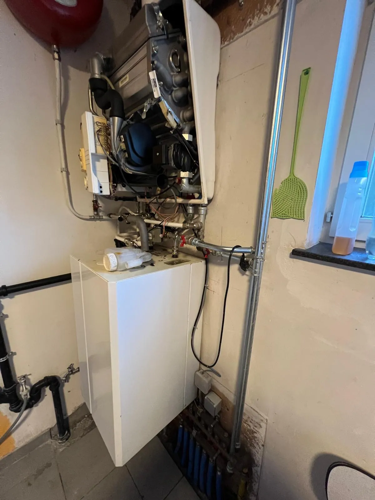 Geopende gasketel tijdens een herstelling van de verwarming door HS Concept, chauffagist in Aalst