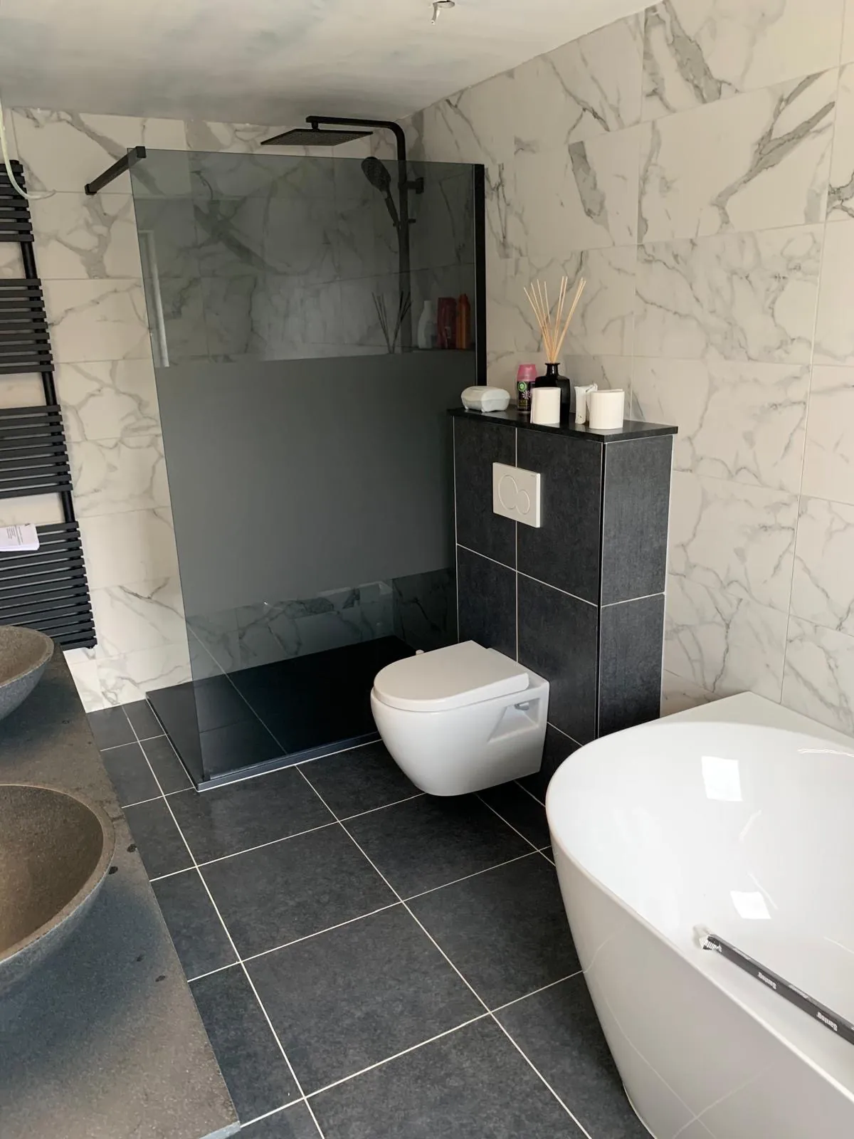 Afgewerkte badkamer met vrijstaand ligbad, inloopdouche en marmerlook tegels, gerenoveerd door HS Concept in Aalst