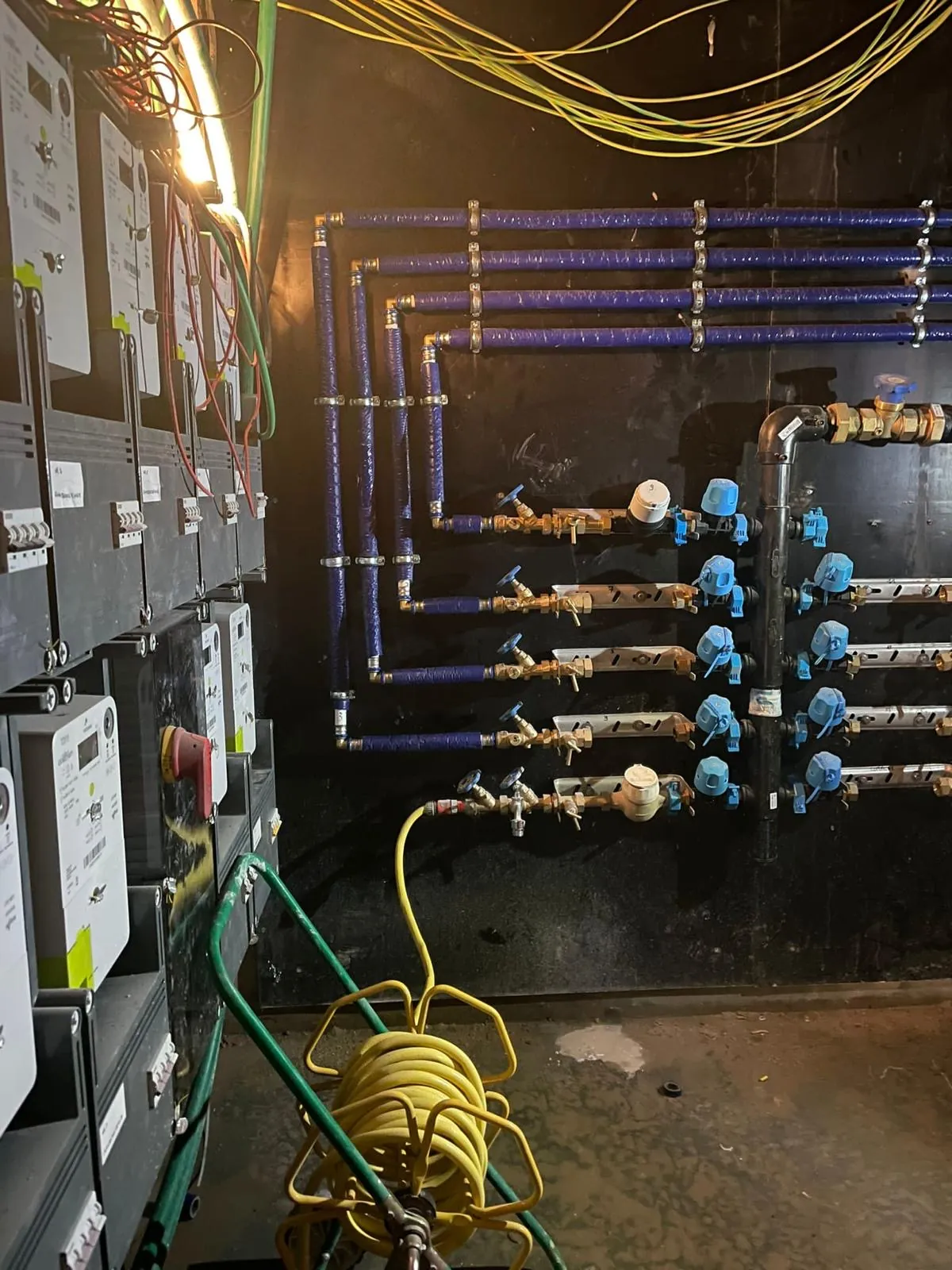 Batterij watermeters met afsluitkranen voor de wooneenheden van een appartementsgebouw, geplaatst door HS Concept in Aalst