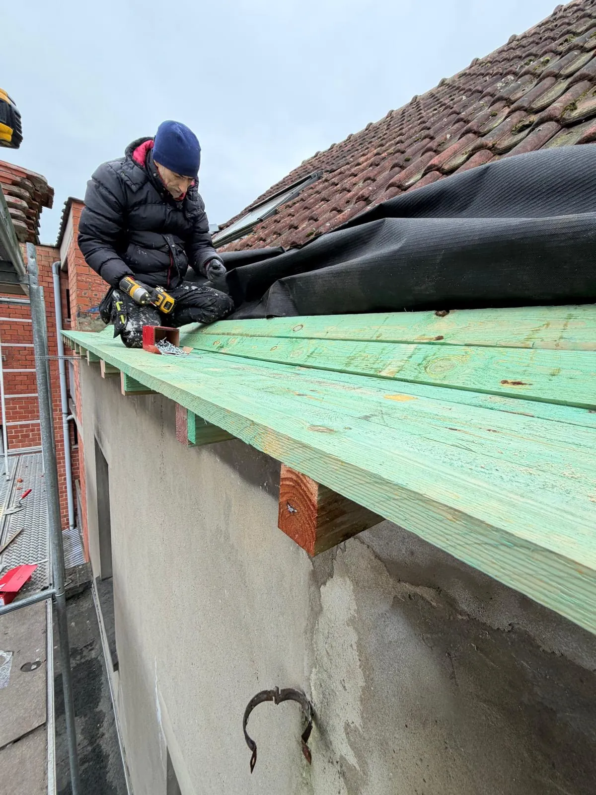 Vakman van HS Concept plaatst een nieuwe dakgoot