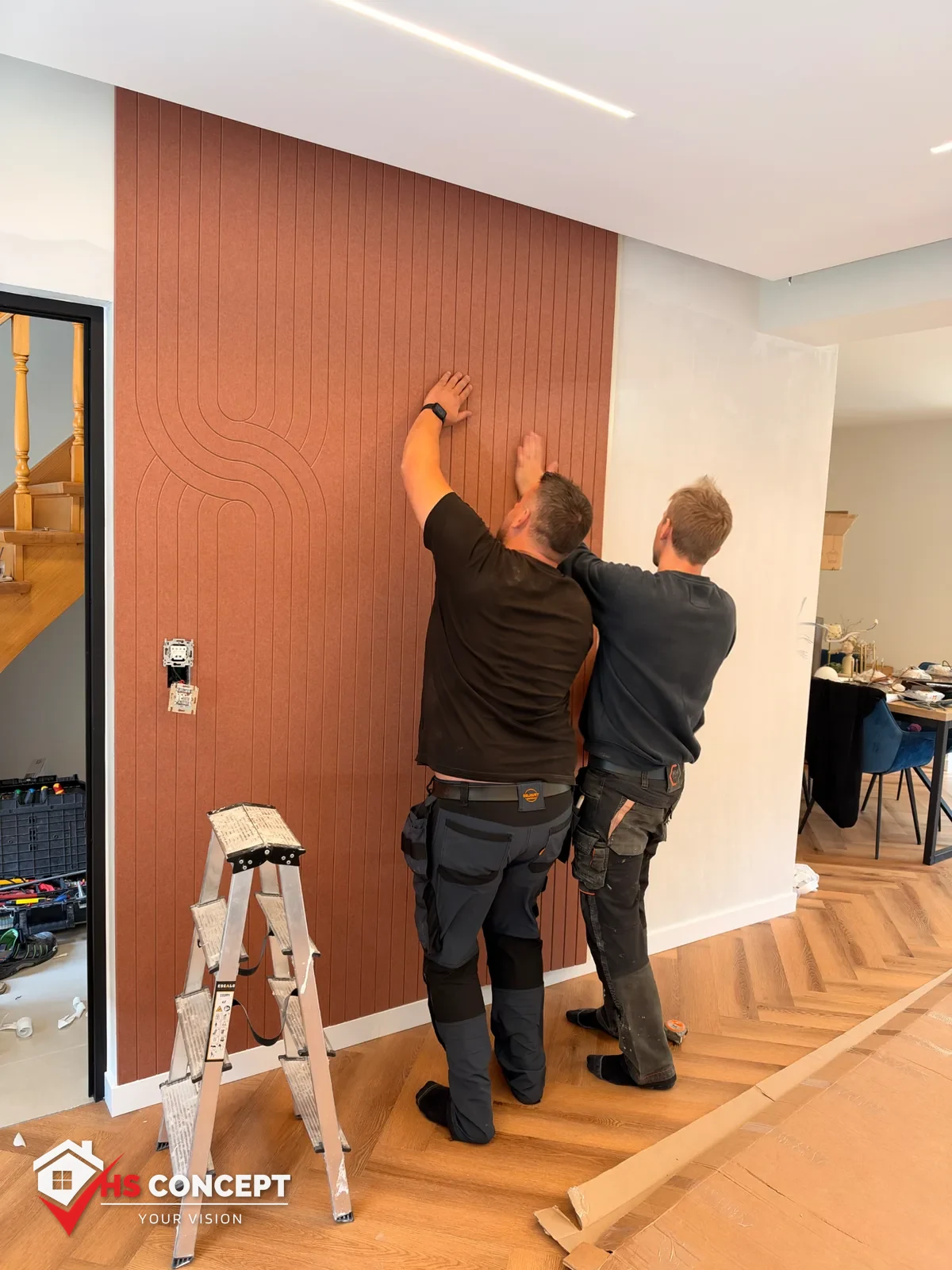 Team lijnt een decoratief wandpaneel nauwkeurig uit in een living