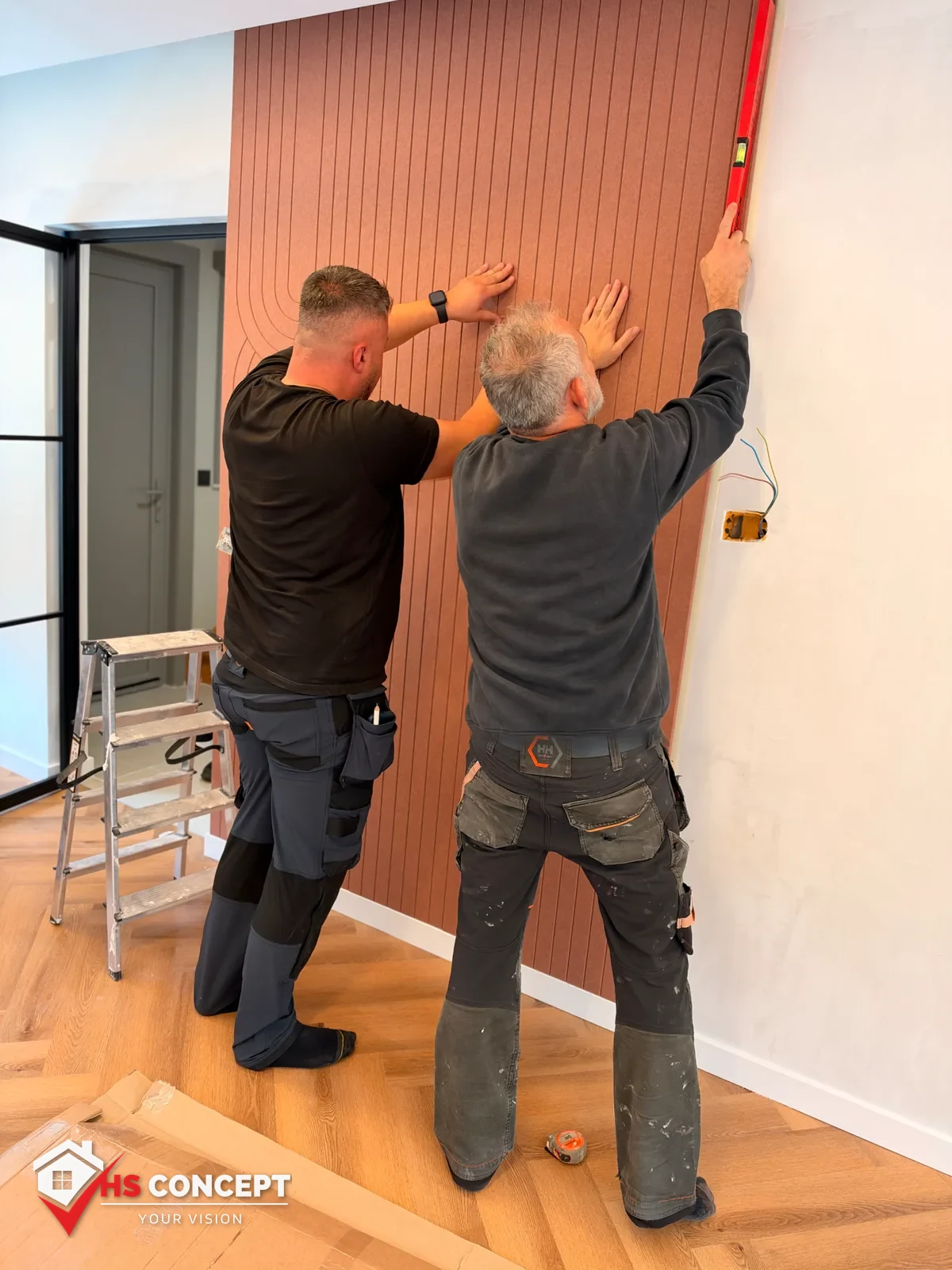 Vakmensen controleren een decoratief wandpaneel met een waterpas